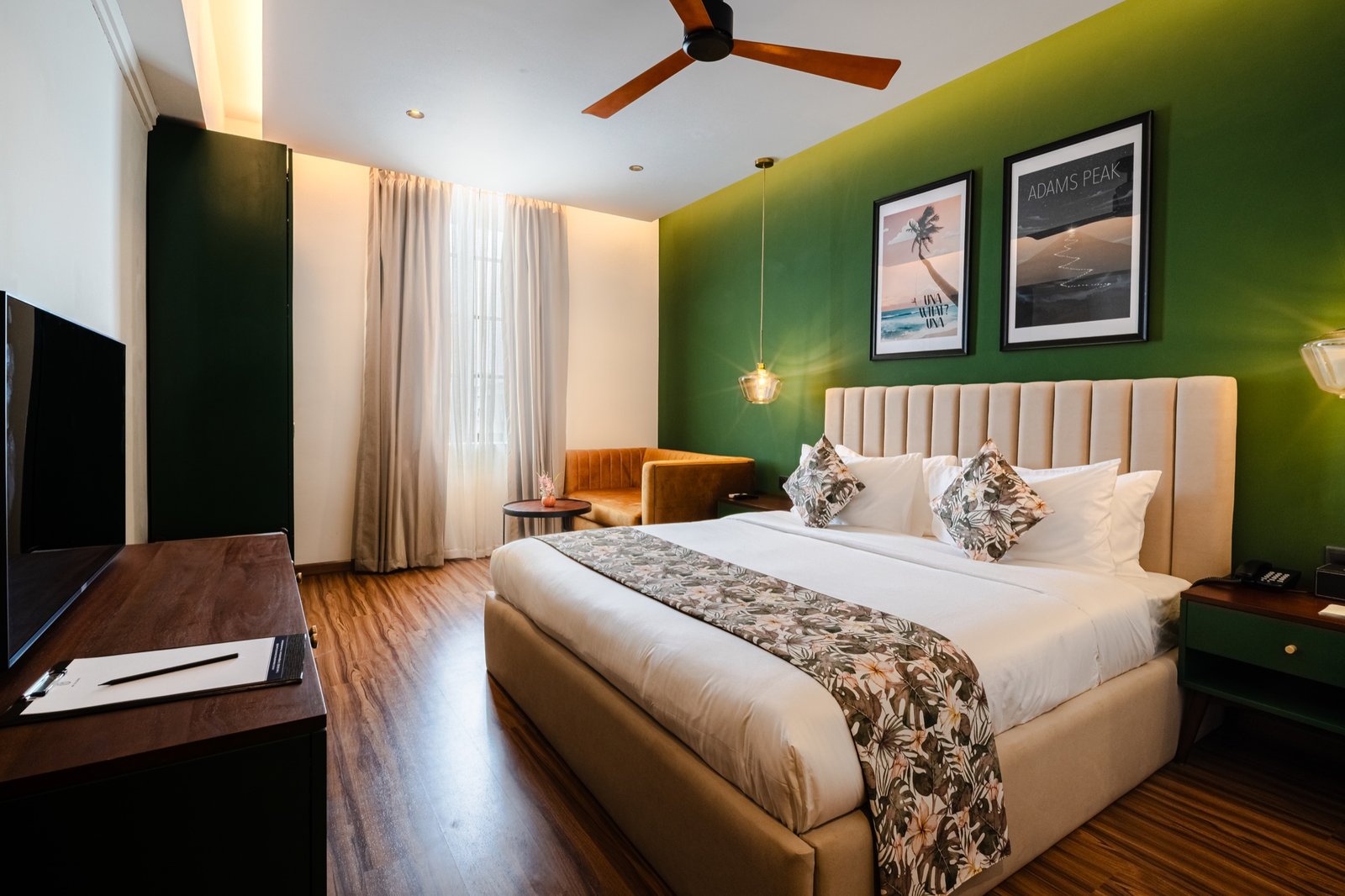 King room with green feature wall and lounge seating